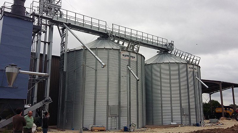 deux silos à fond plat avec séchoir à maïs et élévateur à godets