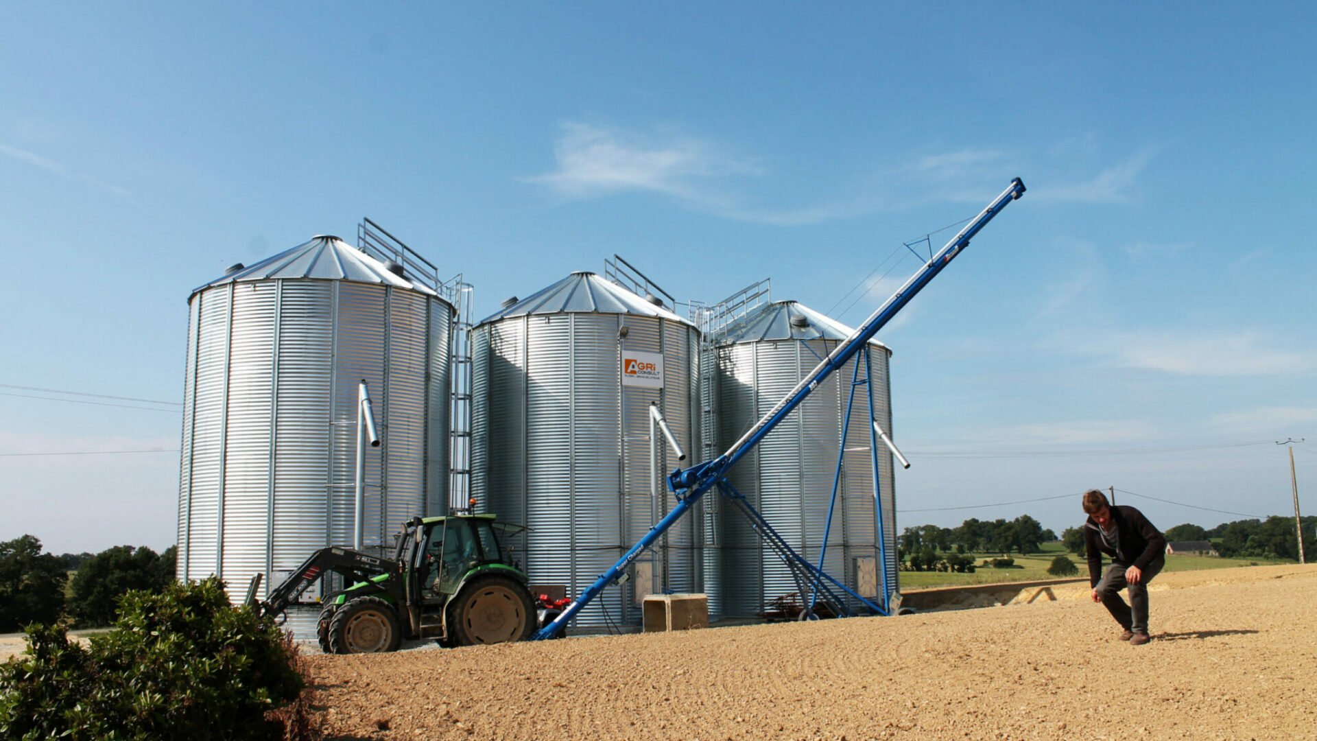 3 silos à grain avec tracteur et vis à grain sur chariot