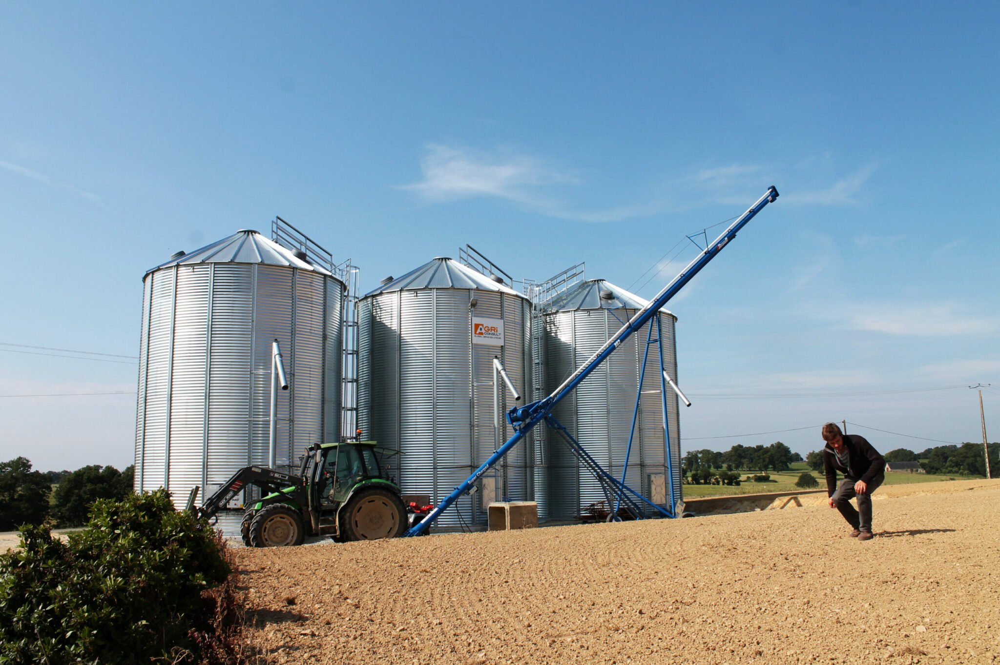 3 silos à grain avec tracteur et vis à grain sur chariot