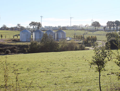 champs avec eoliennes et 4 silos a grains