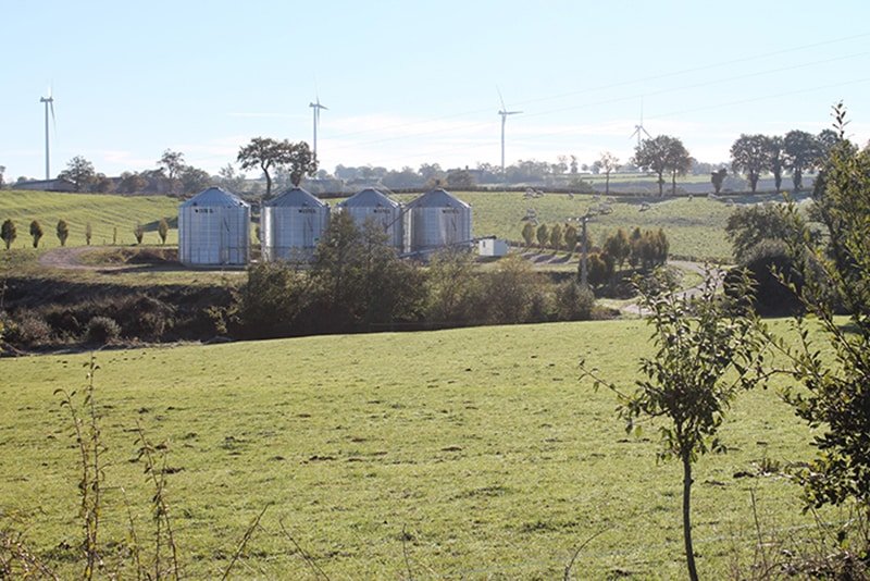 champs avec eoliennes et 4 silos a grains