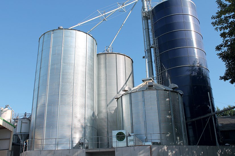 une cellule sécheuse entourée de deux silos à grains et un silo tour