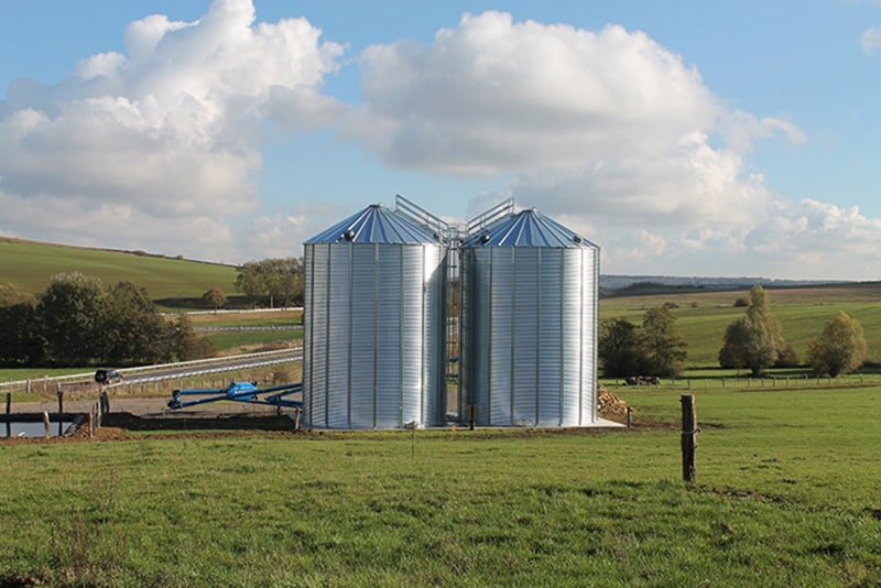 deux silos à grain fond plat au milieu d'un champ