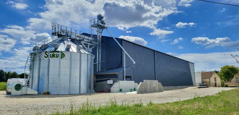 cellule sécheuse sukup agriconsult en extérieur devant batiment avec manutention gamme industrielle et fosse passante avec trémie 3 pentes pré-nettoyeur et ventilateur installation complète